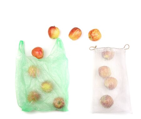 fresh organic apples fruits come from plastic bag to reusable recycled mesh net grocery bag, white background, zero waste shopping concept, conscious consumerism, copy spaceの写真素材