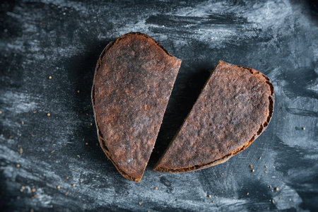 A loaf rye whole grain yeast-free sourdough bread in shape of heart cut in halfの写真素材