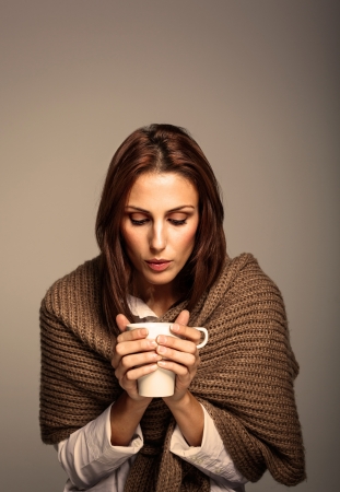 Attractive Woman Drinking a Hot Coffee on a Warm Interiorの写真素材
