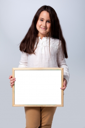 Beautiful Little Girl with a Blank Chalkboard over a Grey Backgrondの写真素材
