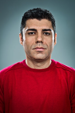 Young Man with Serious Expression over a Grey Backgroundの写真素材