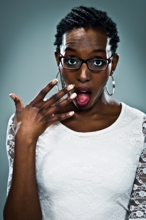 Young Black Woman with Surprise Expression Over a Grey Backgroundの写真素材