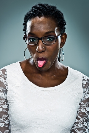 Young Happy Black Woman Sticking Out Her Tongue Over a Grey Backgroundの写真素材