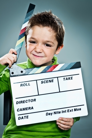 Little Actor with a Slate in His Head over a Grey Backgroundの写真素材