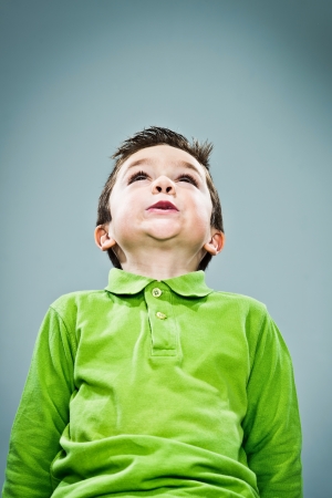 Funny Kid Looking Up on a Grey Backgroundの写真素材