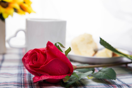 Studio shot of red rose and tea on tableの写真素材