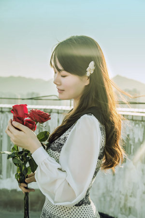Beautiful Asian woman holding red roseの写真素材