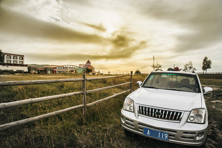 Car beside a ranch with buildings in the backgroundのeditorial素材