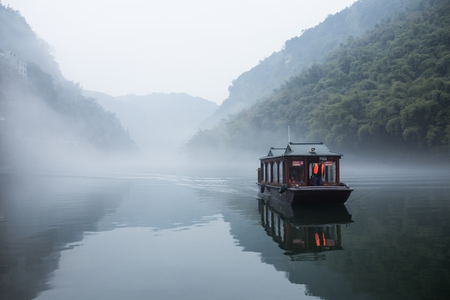 Traditional chinese tourist ferry cruising the foggy watersのeditorial素材