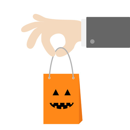 Businessman hand holding shopping paper bag  with pumpkin smile design.のイラスト素材