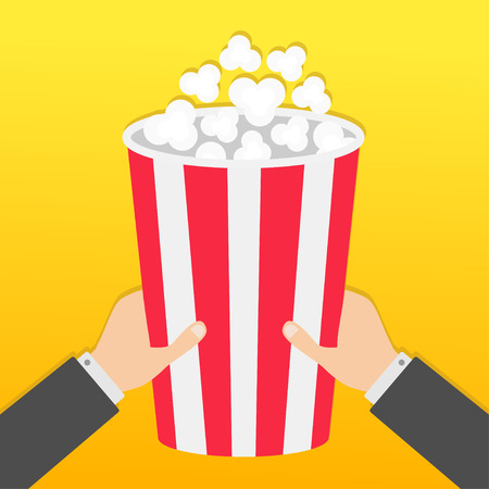 Two human businessman hands holding big popcorn box. Movie Cinema icon in flat design style. Pop corn. Fast food. Yellow gradient background. Vector illustrationのイラスト素材