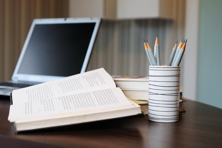 work table with computer notebook,pencil, book in a homeの写真素材
