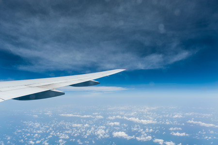 View from airplane window with blue sky and cloudsの写真素材