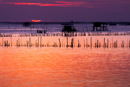 silhouette of thai fishing house at sunsetの写真素材