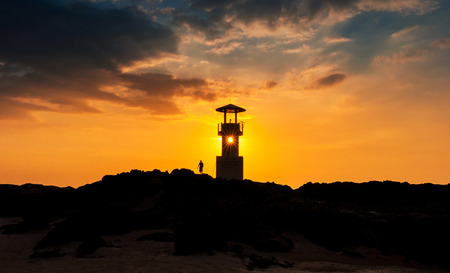 Silhouette of lighthouse at sunset off the coast, thailandの写真素材