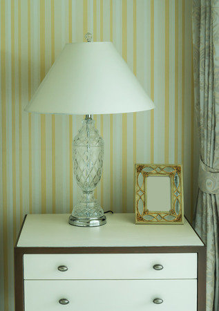 Bedside table with lamp, and picture frameの写真素材