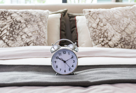 classical alarm clock on bed