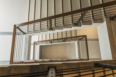 staircase with wooden rail in a modern buildingの写真素材