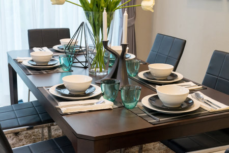 dining table and comfortable chairs in modern home with elegant table setting