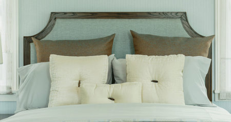 cozy bedroom interior with white pillows and reading lamp on bedside table