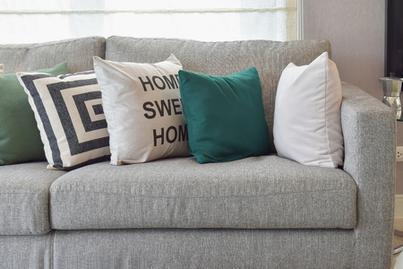 Retro pillows on the cozy grey sofa in the living roomの写真素材