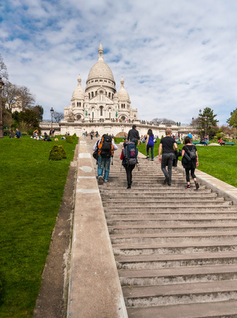 Paris, France - April 15, 2013: Tourists stroll in Montmartre near Basilica Sacre Coeur designed by Paul Abadie, 1914 - Roman Catholic Church and minor basilica, dedicated to Sacred Heart of Jesus.のeditorial素材
