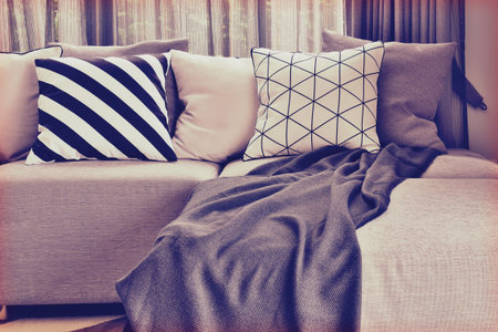 Light gray L shape sofa with varies patern and colos pillows in living corner