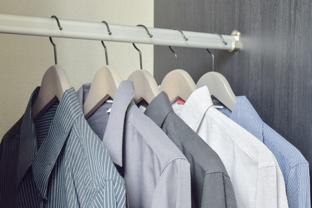 row of black and white shirts hanging in wardrobeの写真素材