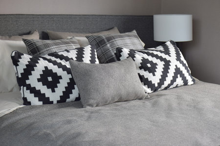 Graphic style and grey shade pillows on classic color bedding set up