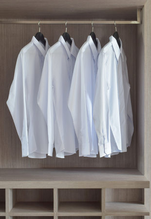 Classic white shirts in warm wooden wardrobeの写真素材