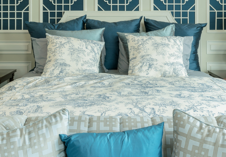 classic style bedroom with white and blue pillows on bedの写真素材