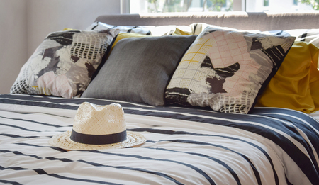 antique straw hat on black and white patterned bed at homeの写真素材