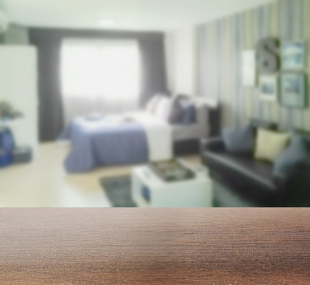 wooden table top with blur of blurred background bedroom with sofaの写真素材