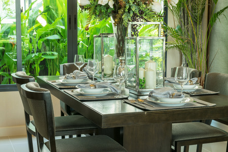 table set on wooden table and chairs in tropical dinning roomの写真素材