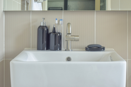 Square lavatory and ceramic bottles in bathroomの写真素材