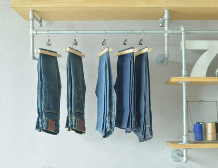 jeans hanging in industrial style walk in closetの写真素材