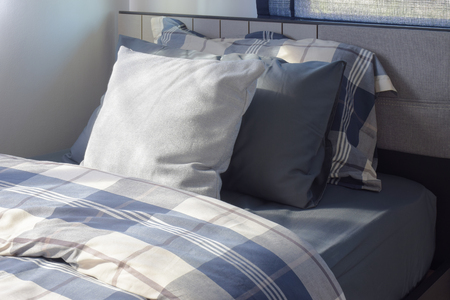 White and deep blue pillow on bed checked pattern bedding in modern interior bedroomの写真素材