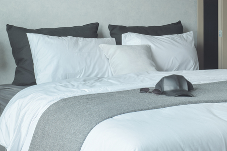 Cap and sunglasses on king size bedの写真素材