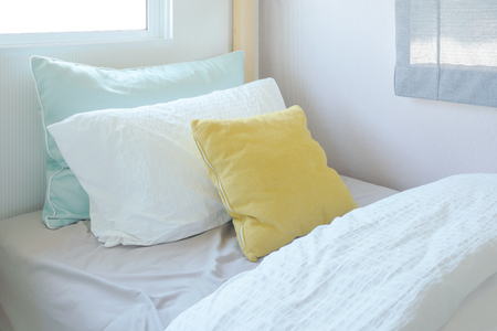 Yellow and green pillow on tiny bed in kid bedroom interiorの写真素材