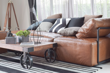 Wood center table with wheel and light brown leather sofa in industrial style decorationの写真素材