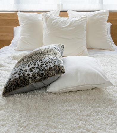 decorative black and white pillows on bed in stylish bedroom interiorの写真素材