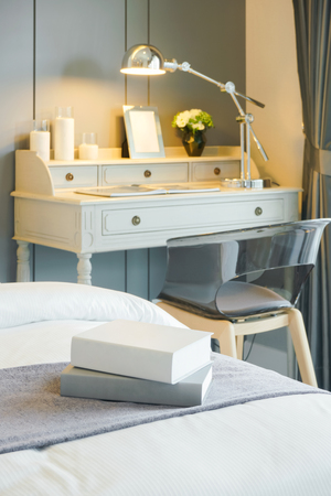 Books on bed with working table in backgroundの写真素材