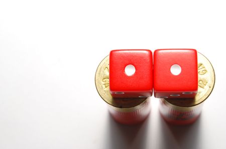 Two dice lying on 12 guage shotgun shells. Dice showing snake-eyes with focus on top of shells.の写真素材