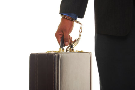 African american male wearing a business suit handcuffed to a briefcase.