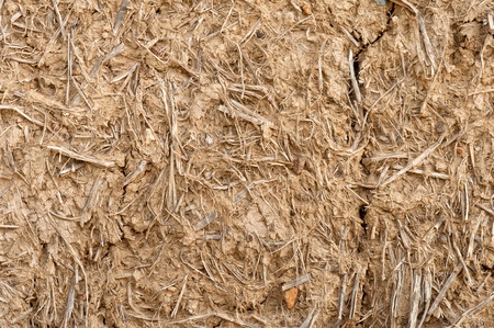 Old cracked wall made of orange clay and strawの写真素材