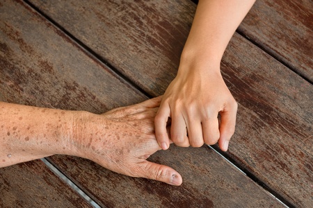 old and young woman hands touchingの写真素材
