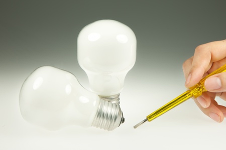 Screwdriver and Light Bulb on White and gray Backgroundの写真素材