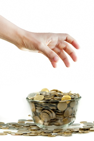 Hand  going to pick up coins in glass blowの写真素材