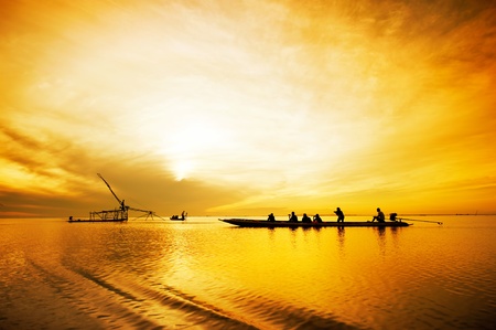 tourist travelling fisherman fishing at sunrise , thailandの写真素材