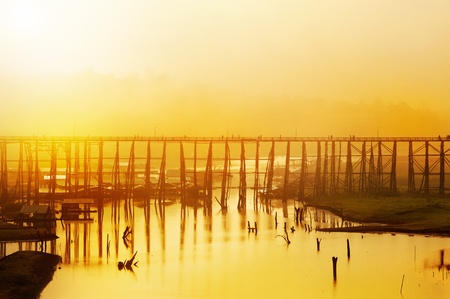 wood bridge over river in foggy morningの写真素材